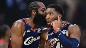 James Harden dice algo al oído de Donovan Mitchell.